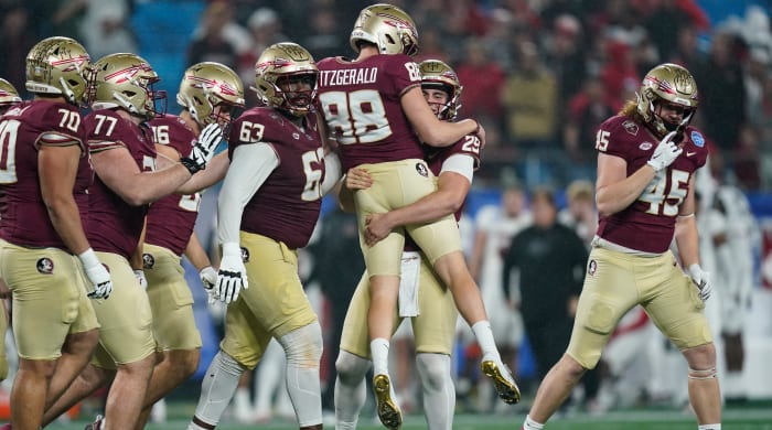 Florida State kicker Ryan Fitzgerald is lifted by Alex Mastromanno after kicking a field goal against Louisville during the second half of the ACC championship.